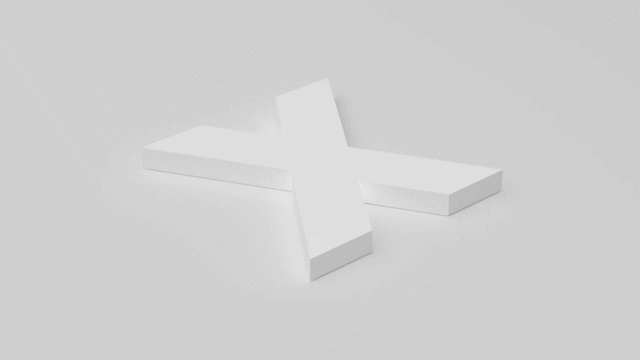 Three-dimensional white cross resting on a light gray surface.