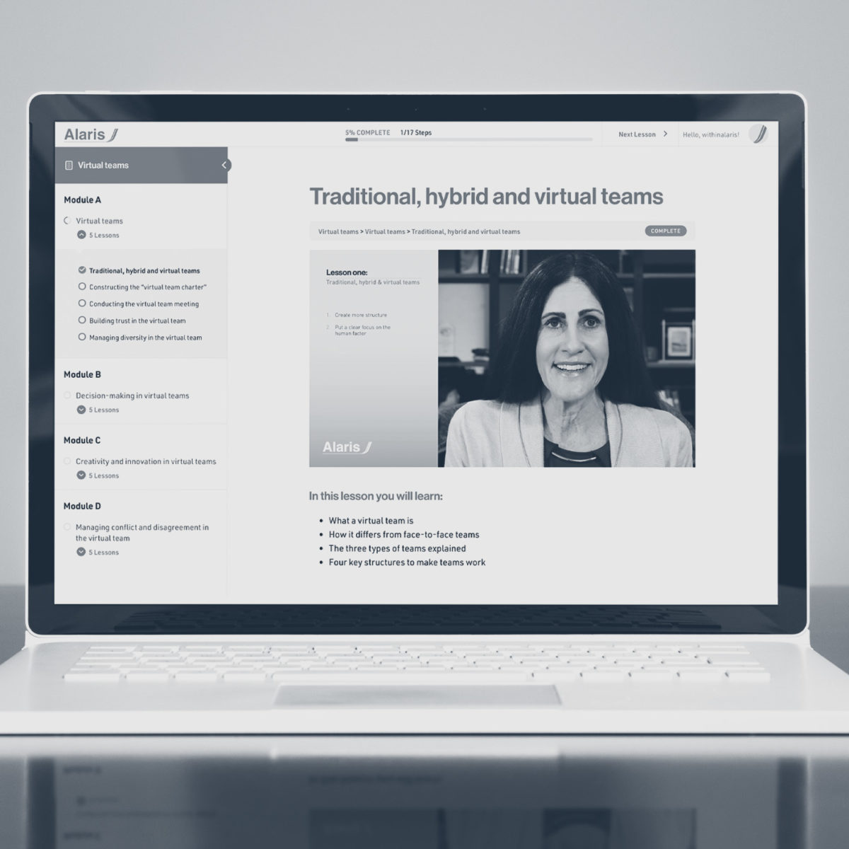 A photograph of a laptop on a table with a page open from the Alaris online course.